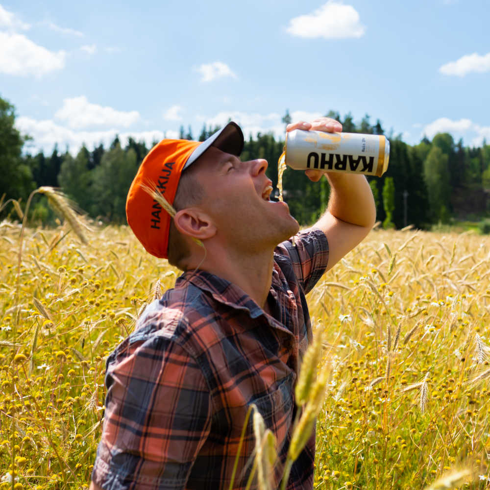 mies juo olutta pellolla